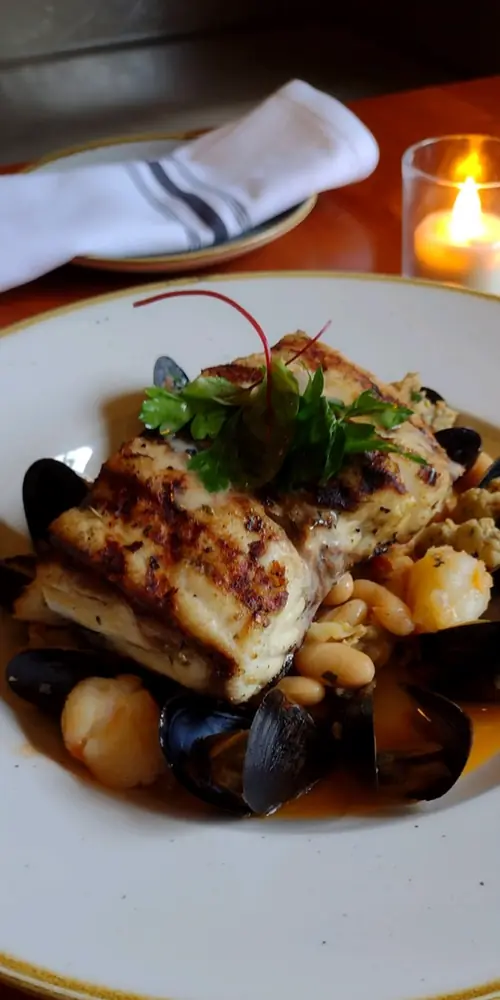 Wood Grilled Striped Bass; served with chicken sausage, white bean, shrimp & mussel ragu 🐟🦪🍅 On spec