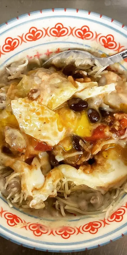 My breakfast this morning: an over easy egg on a bed if beans and rice with some cheese, some sausag