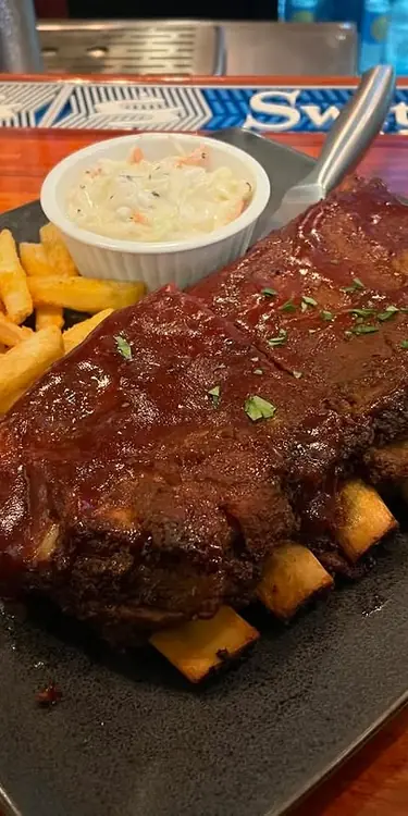 Half rack of St. Louis baby back ribs covered in bbq sauce. Served with French fries and coleslaw.